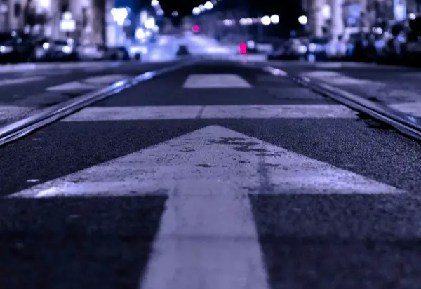 Arrow pointing down a street at night